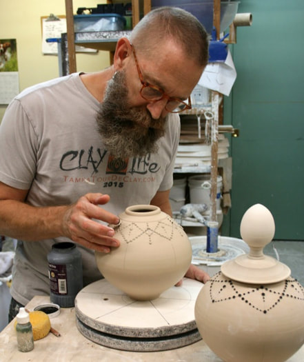 Man shaping handmade pottery urn 