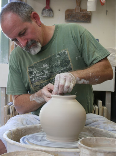 Man shaping handmade urn